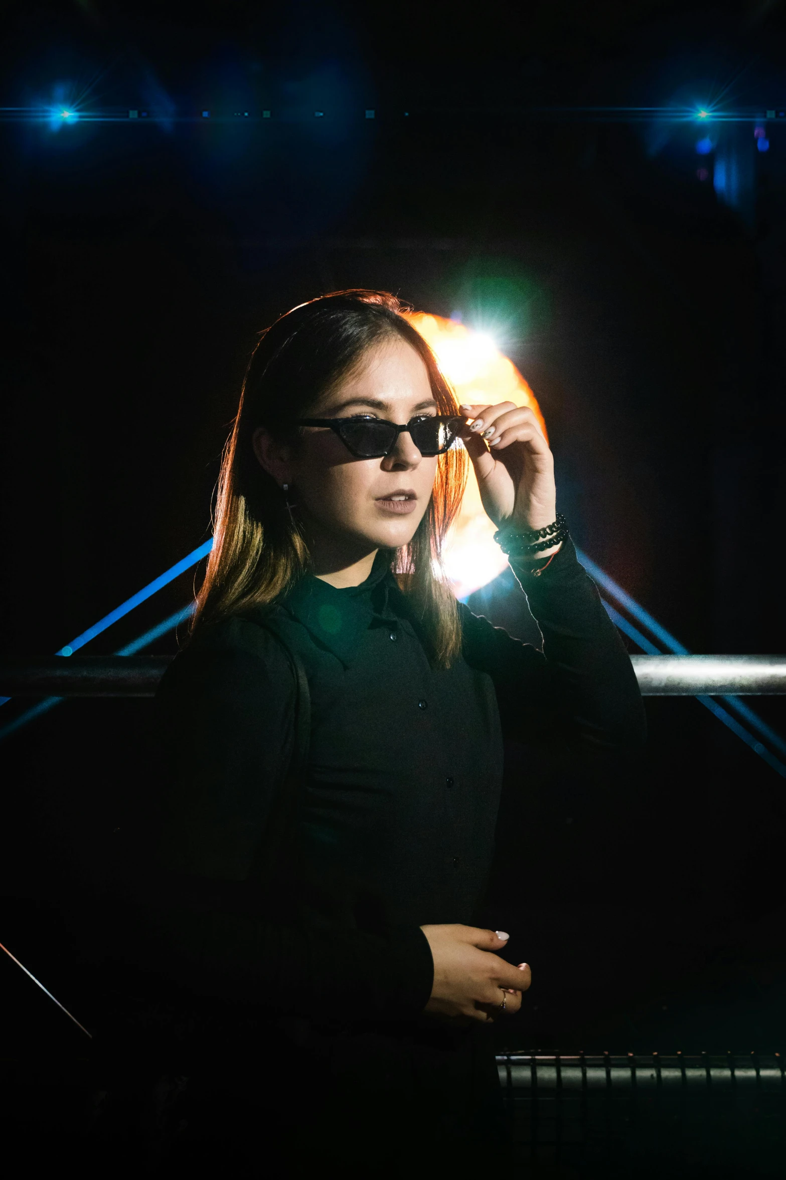 a girl standing at night wearing sunglasses