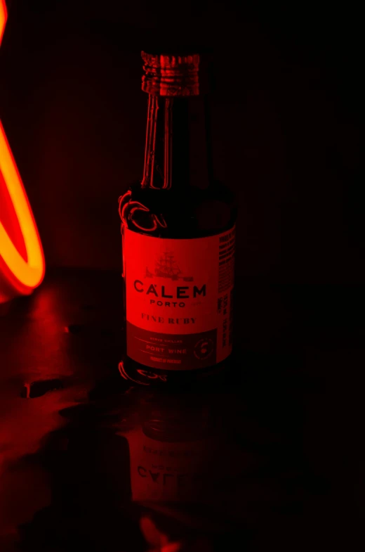 a glass bottle sitting on a table next to a red light