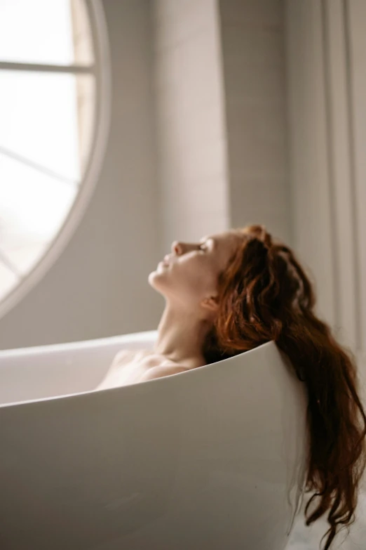 a woman is laying down in a bathtub