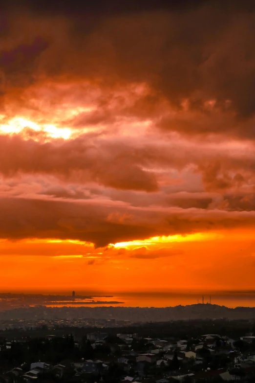 the view from a hill at sunset in front of dark clouds