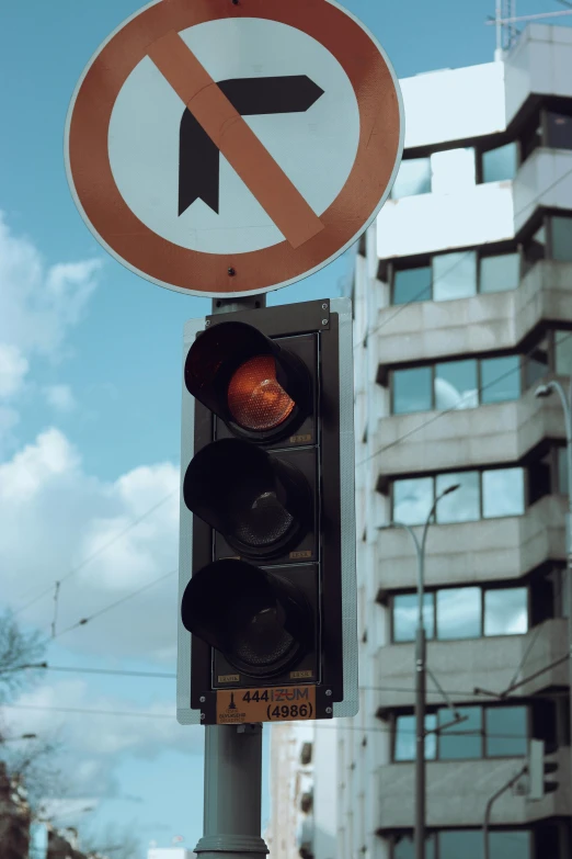 a street sign and traffic light with sky in the background