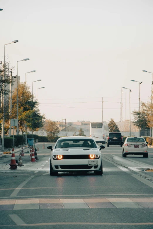 two vehicles in a busy city street with caution cones