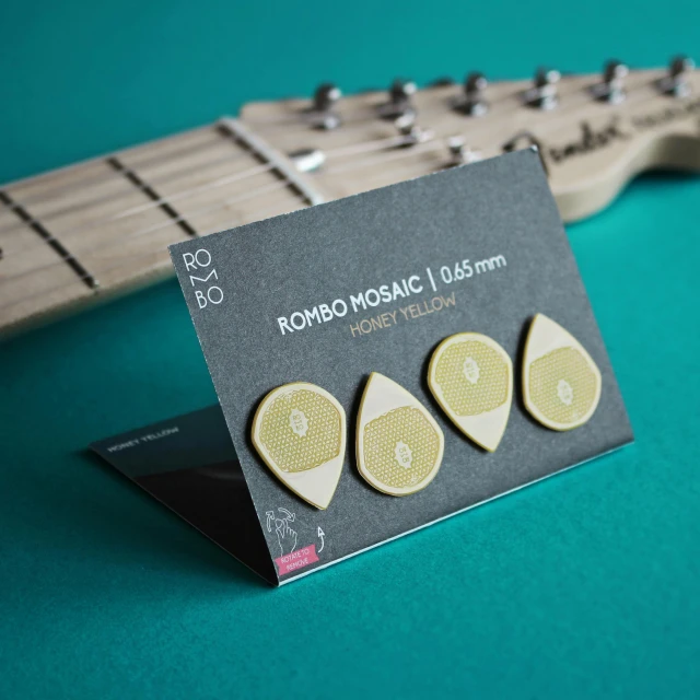 a close up of a guitar pick with some yellow stickers