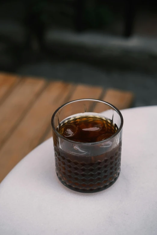 a beverage is sitting in a glass on the table