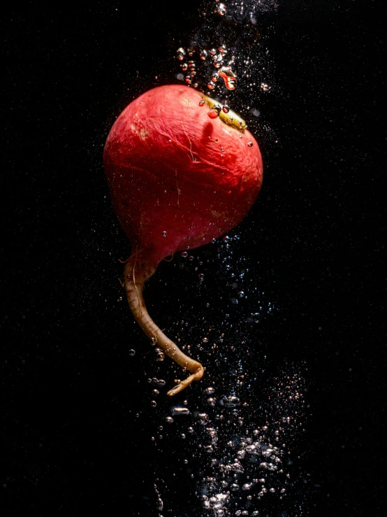 an apple with water drops falling around it