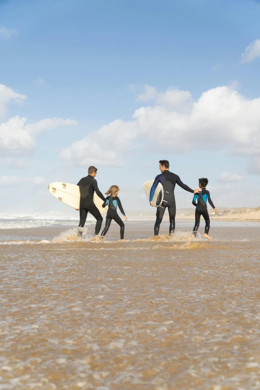 a group of surfers walking out of the water