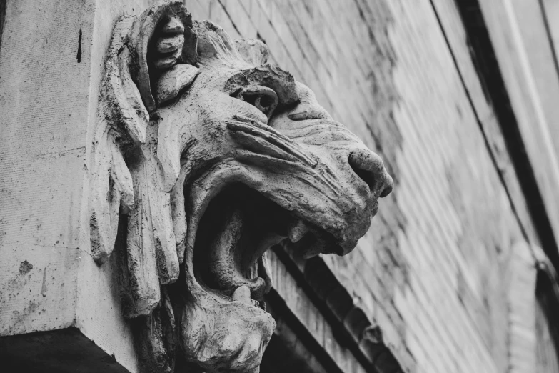 an old gargoyle is standing on the side of a building