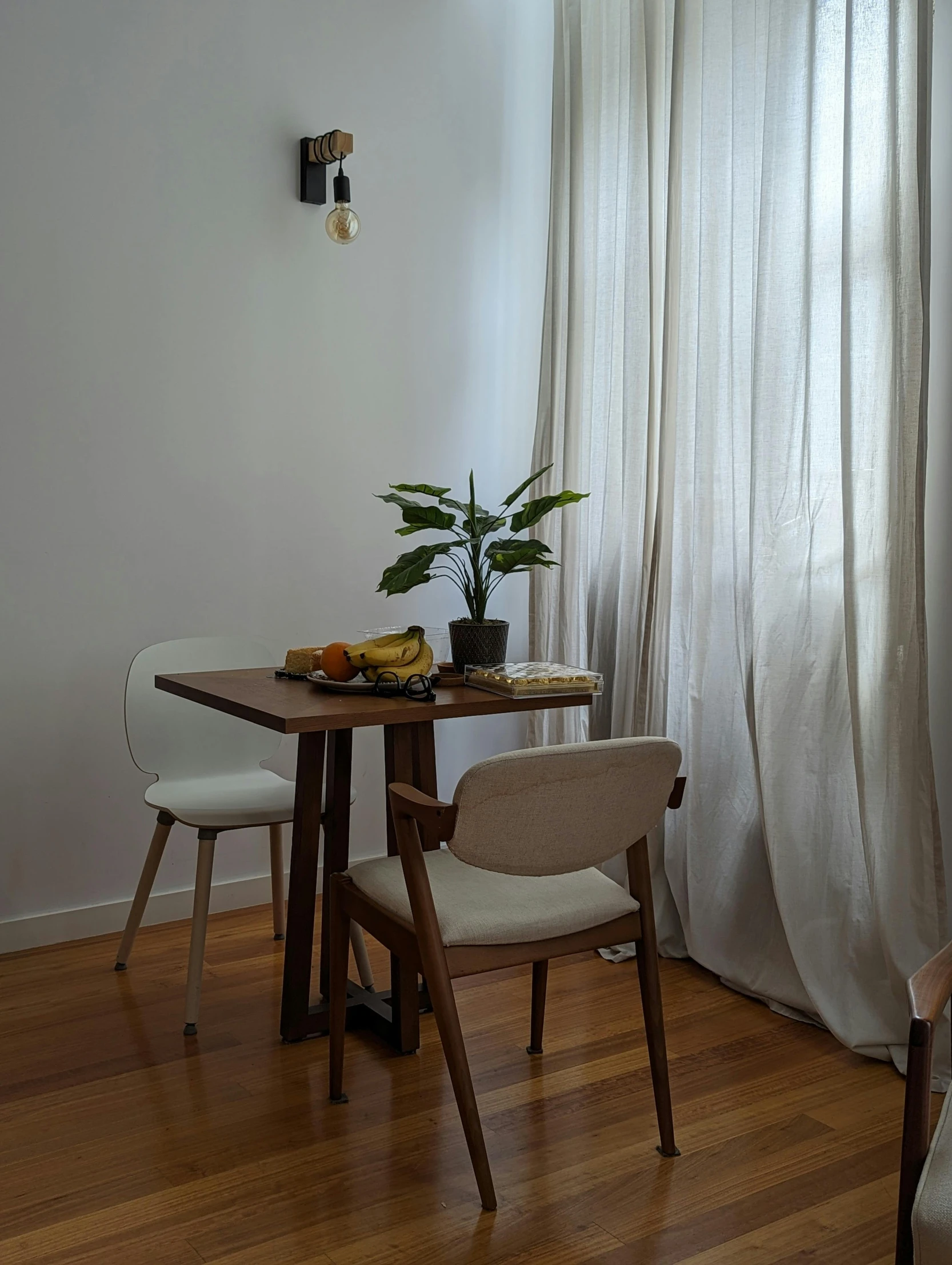 a room with two chairs, table and window