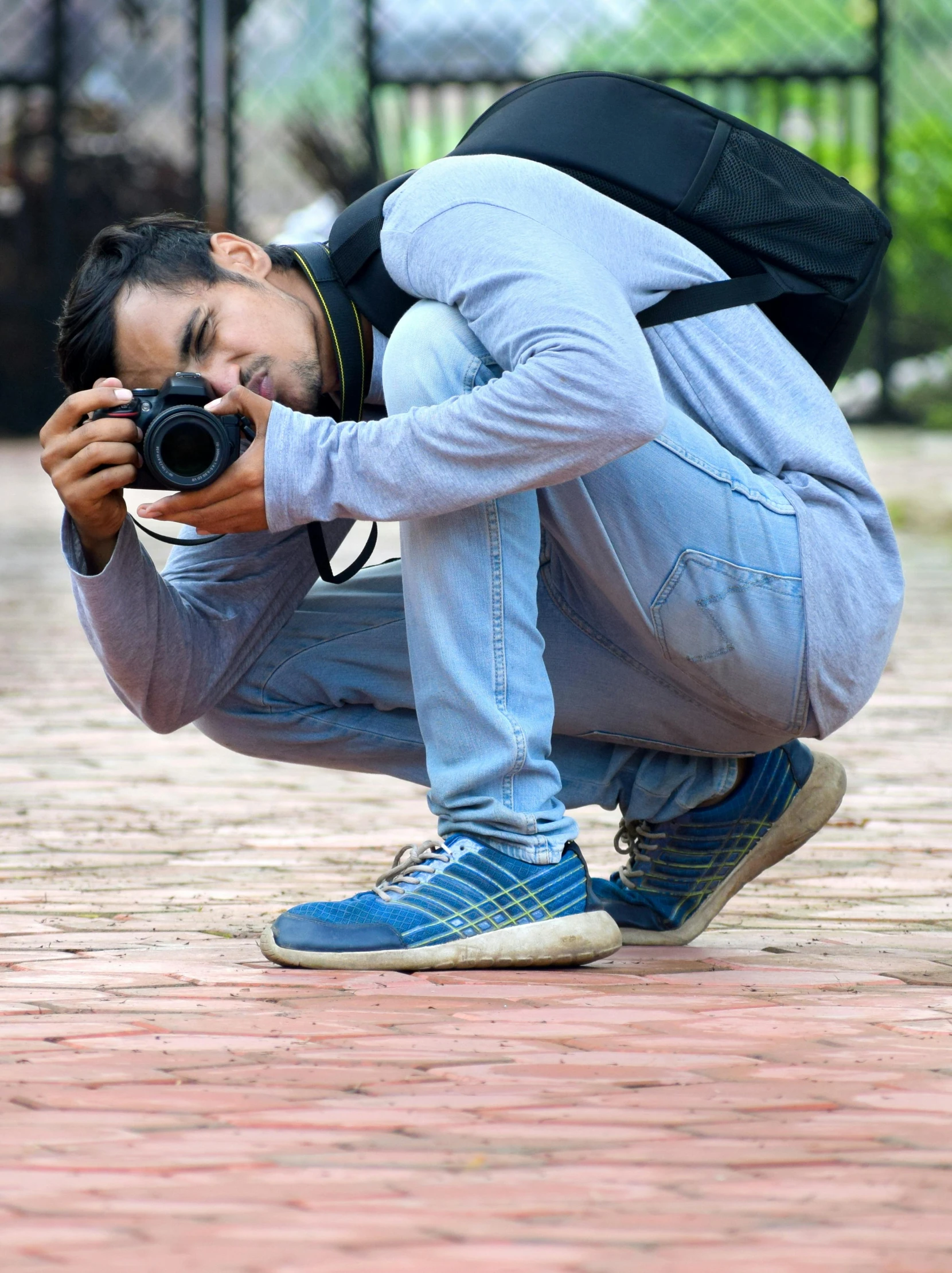 man kneeling and taking picture with camera phone