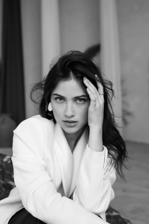 woman in white coat laying on top of a bed