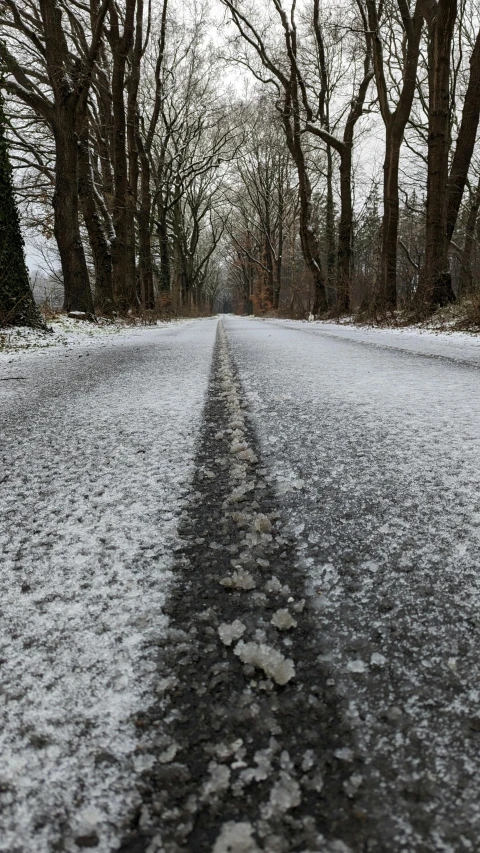 a snow covered road with snow and trees