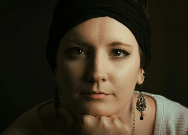 a woman is dressed in all black with earrings and a black top