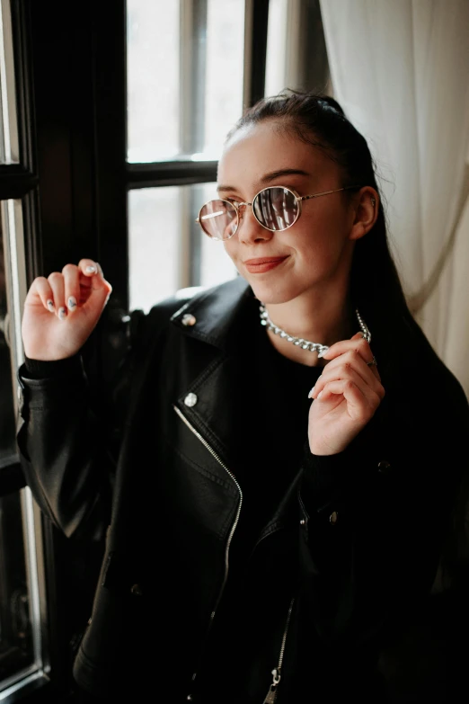 a woman in a black jacket and pearls and sunglasses