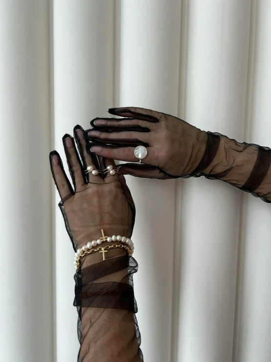 a woman wearing sheer, long and net gloves and jewelry