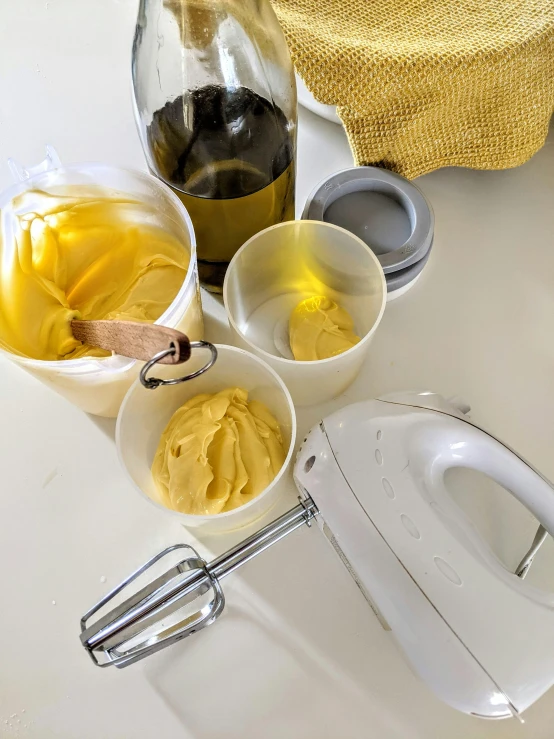 a blender is next to bowls of yellow liquid