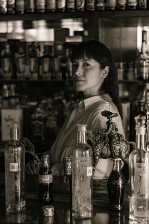 there is a woman standing behind the bar