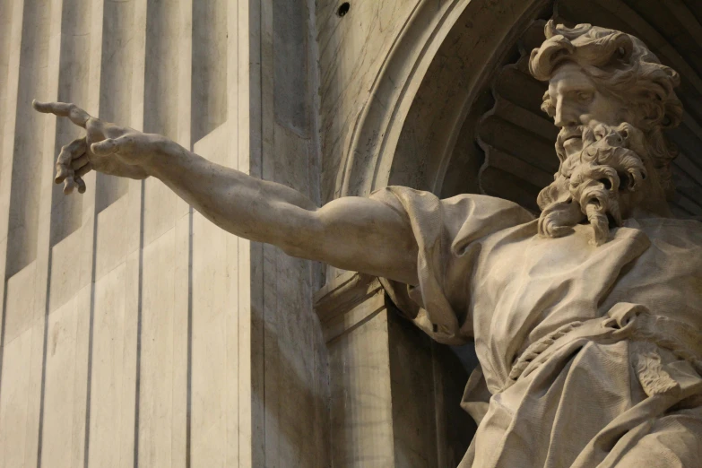 a statue of jesus with his arms outstretched, points at soing