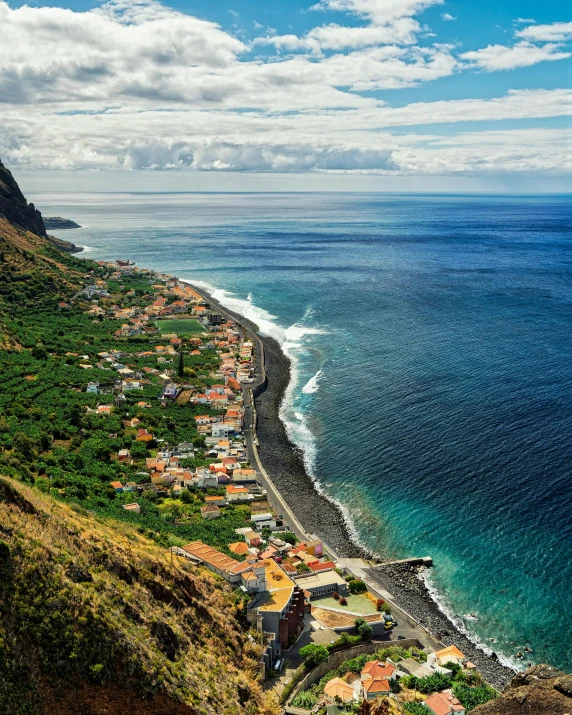 an aerial view of some people and buildings on the side of a cliff