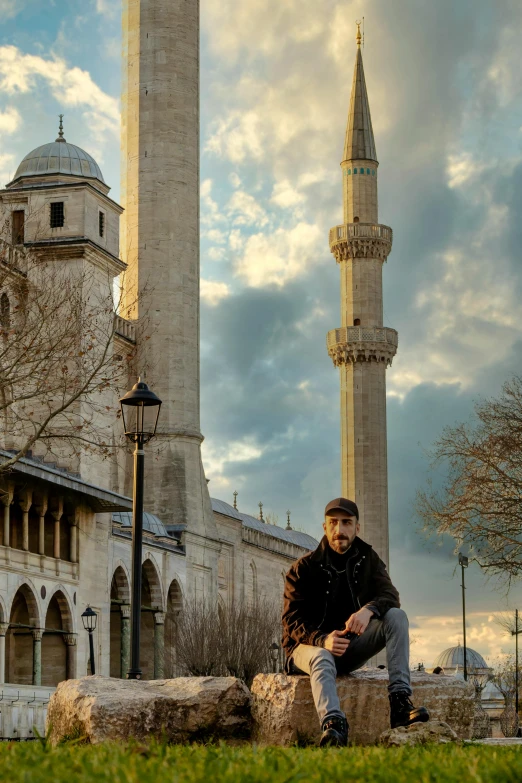 a man sitting on a rock outside an old building