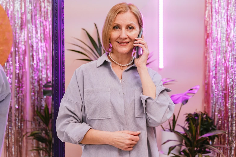 a woman talking on her phone in front of a mirror