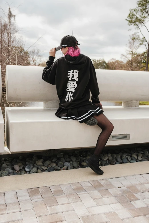 the woman is sitting on the bench with her pink hair