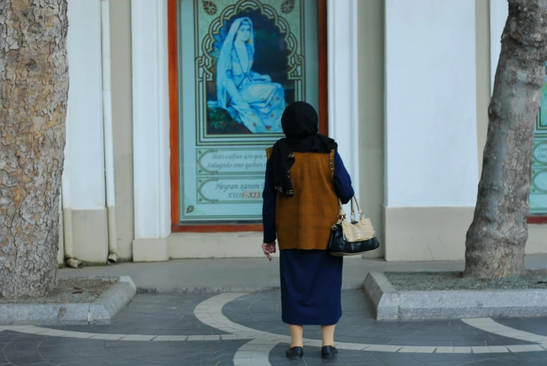 a woman walks down the sidewalk carrying two bags