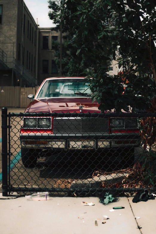 a classic car sits in a gated parking lot