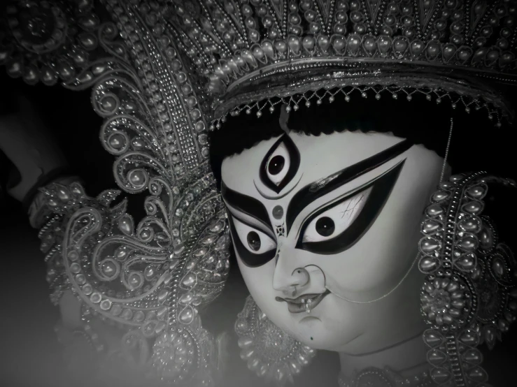 black and white mask with silver designs and eyes