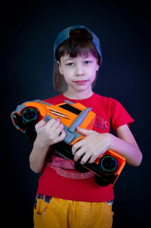boy holding toy gun and wearing hat on black background