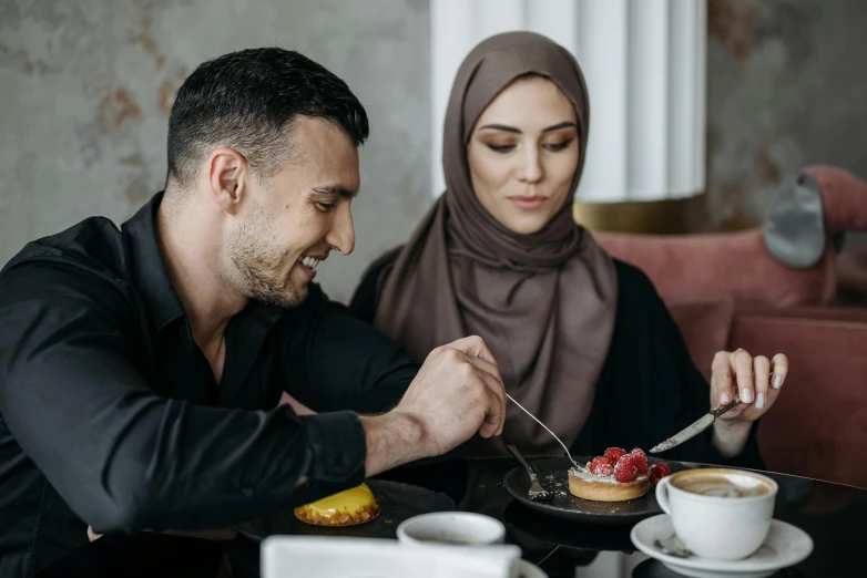 a man and woman eating together at a table