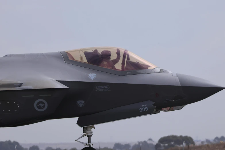 a fighter jet flying through a cloudy gray sky