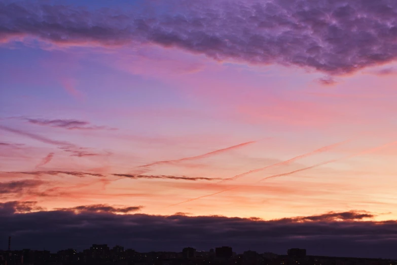 a plane flying at dusk as the sun sets