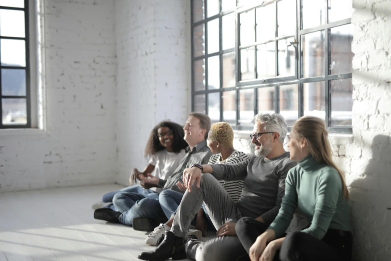 a group of people sitting on top of a white tile floor