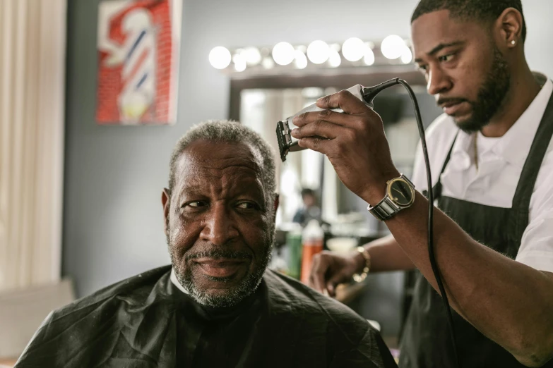 a man at a haircut salon getting ready to cut another man's hair