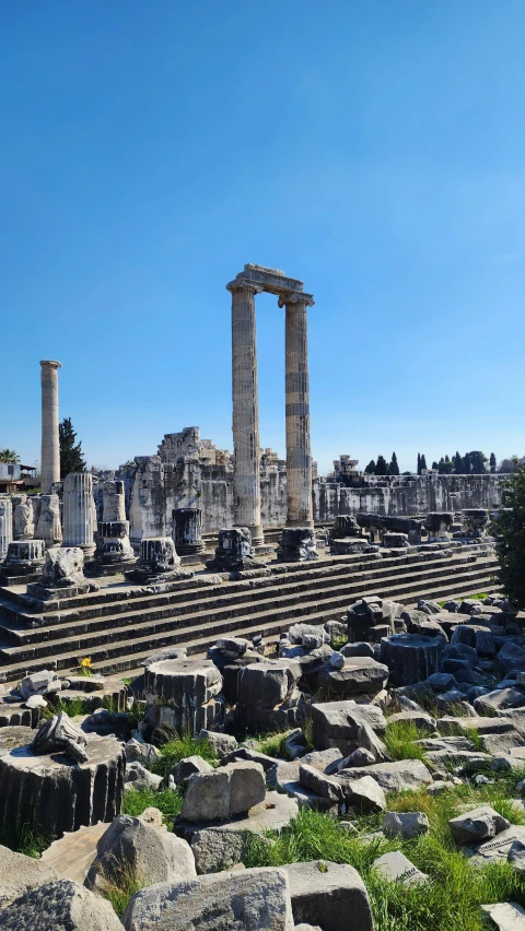 large columns sit in the middle of stone ruins