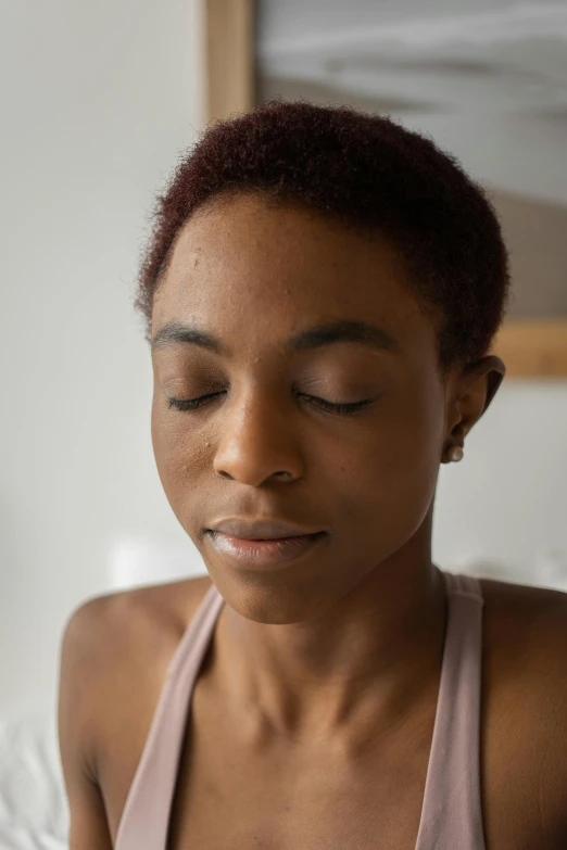 a woman looking down while wearing a brown shirt