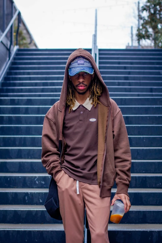 the man stands near some stairs with his arms folded