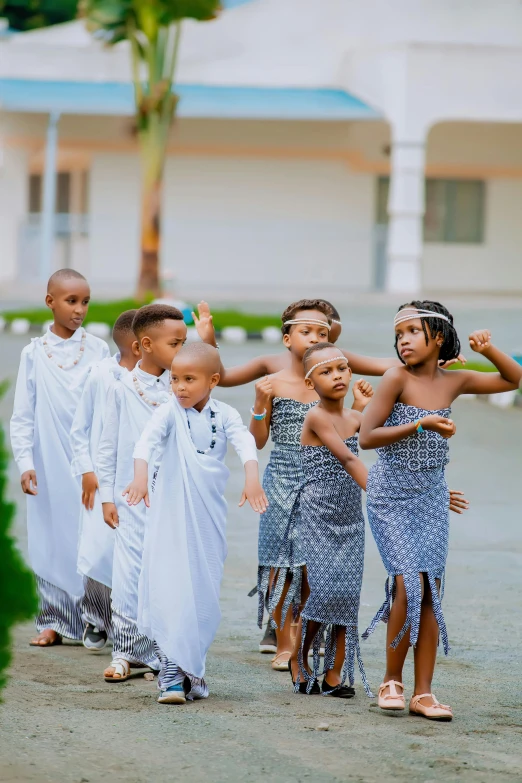 children dressed in african clothing dancing on dirt path