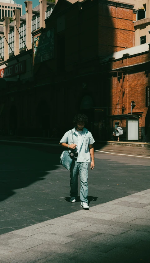 a man with a camera standing on the street