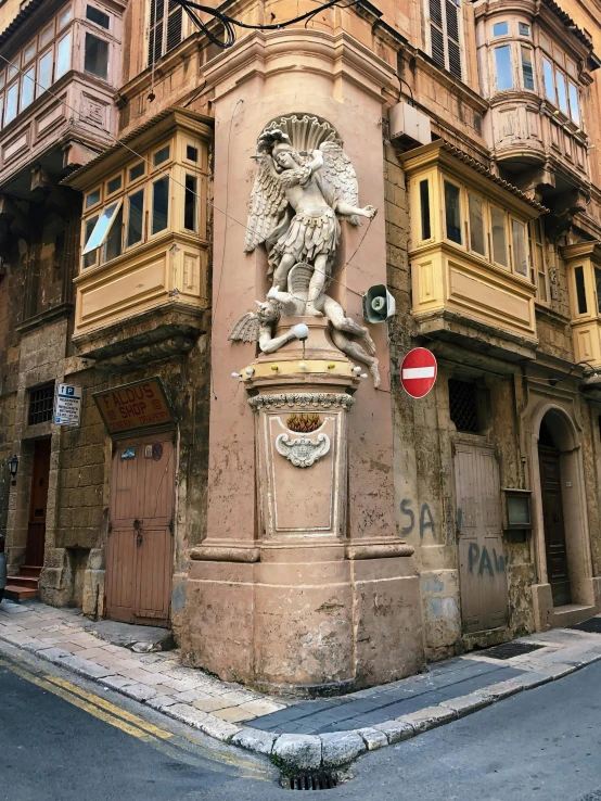 a large old stone clock on the corner of a street