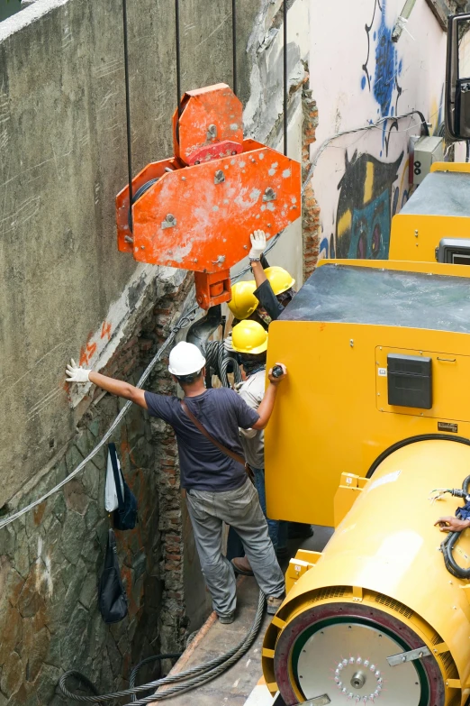 a person is on a crane above a concrete wall