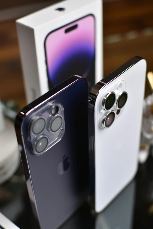 two smartphones on a table with a box