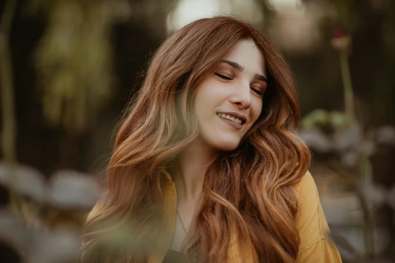 a woman with her eyes closed walking in the woods