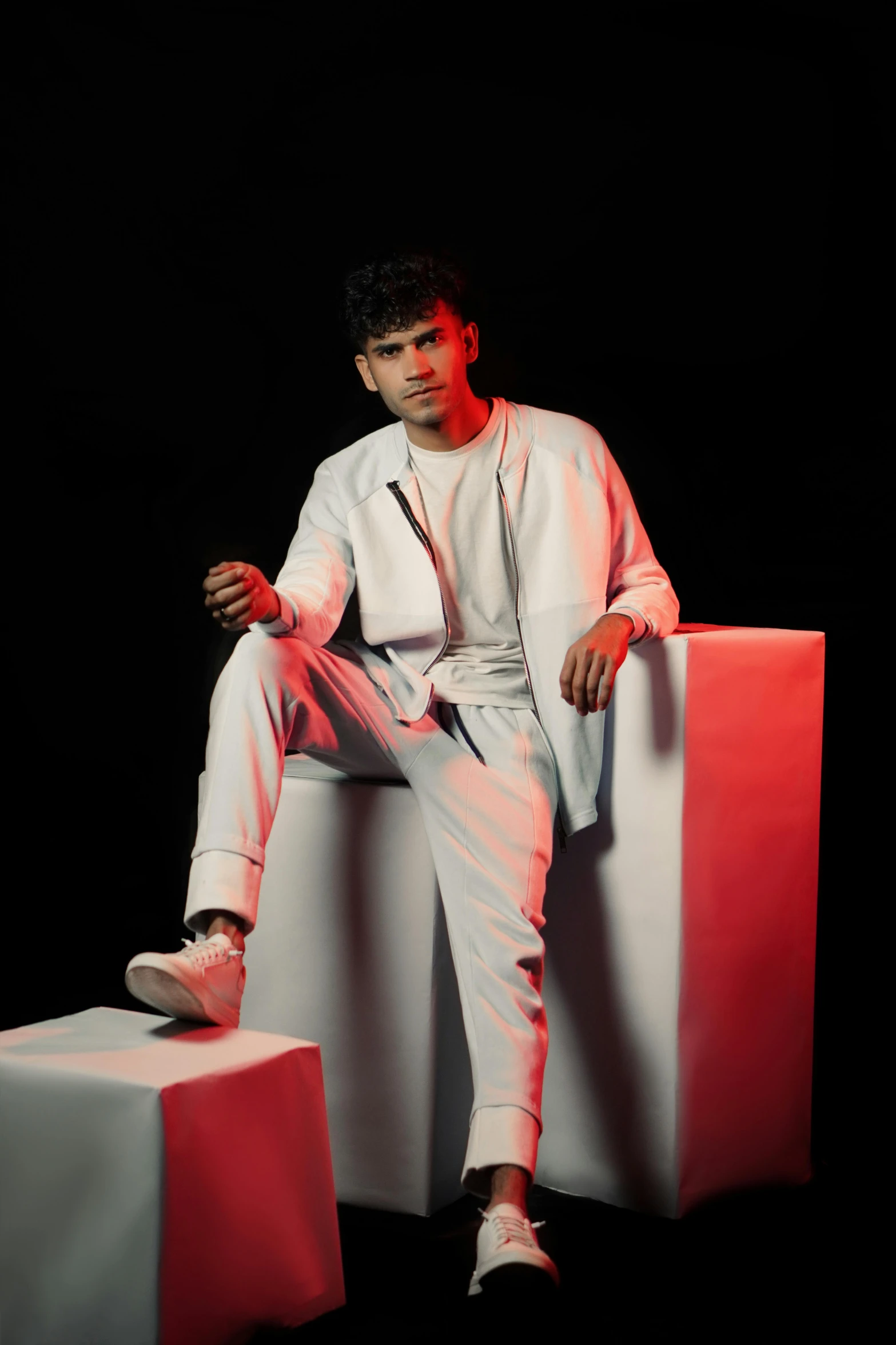 a man is sitting on top of cubes with white paint