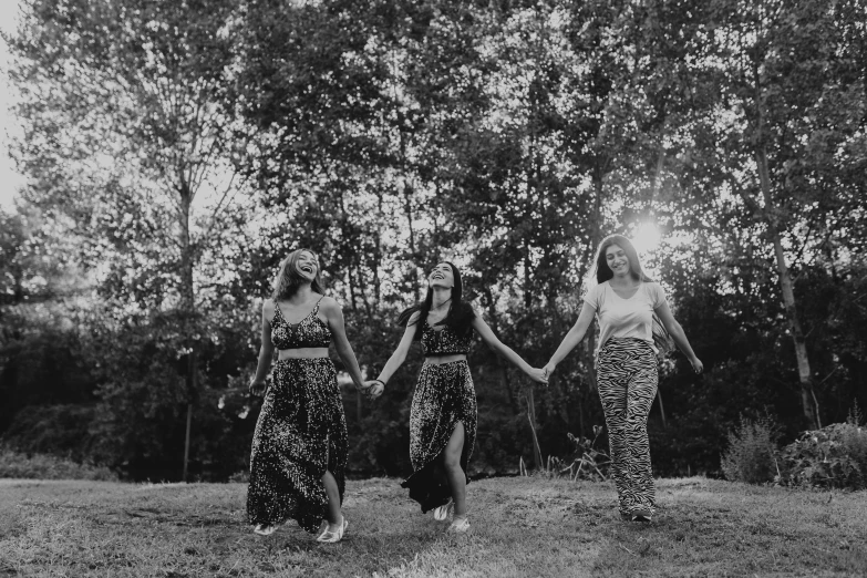 three women walking in the grass, dressed in animal prints
