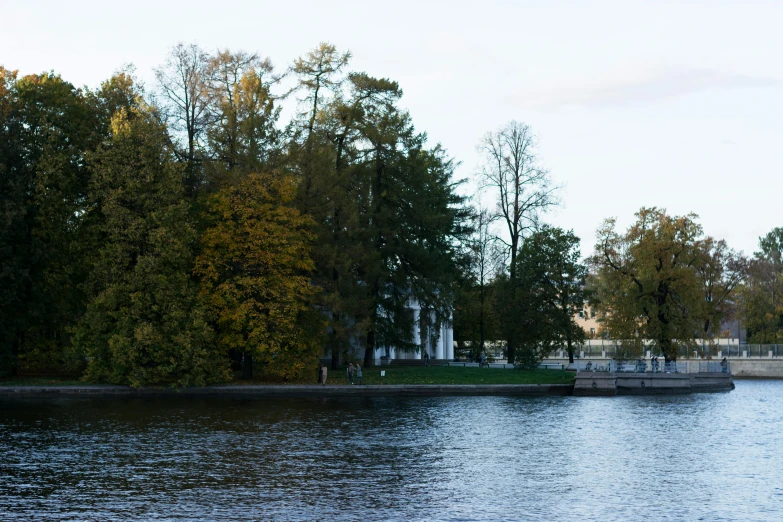 a boat traveling down a lake surrounded by trees