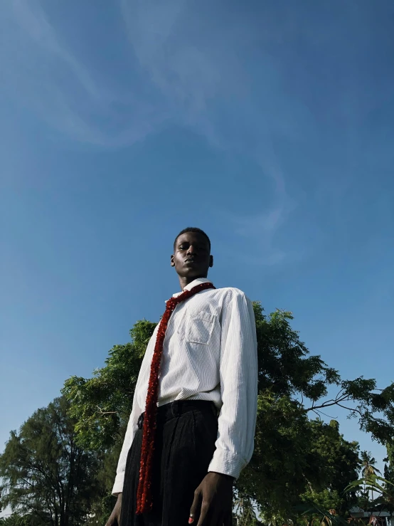 a black man with a red tie standing