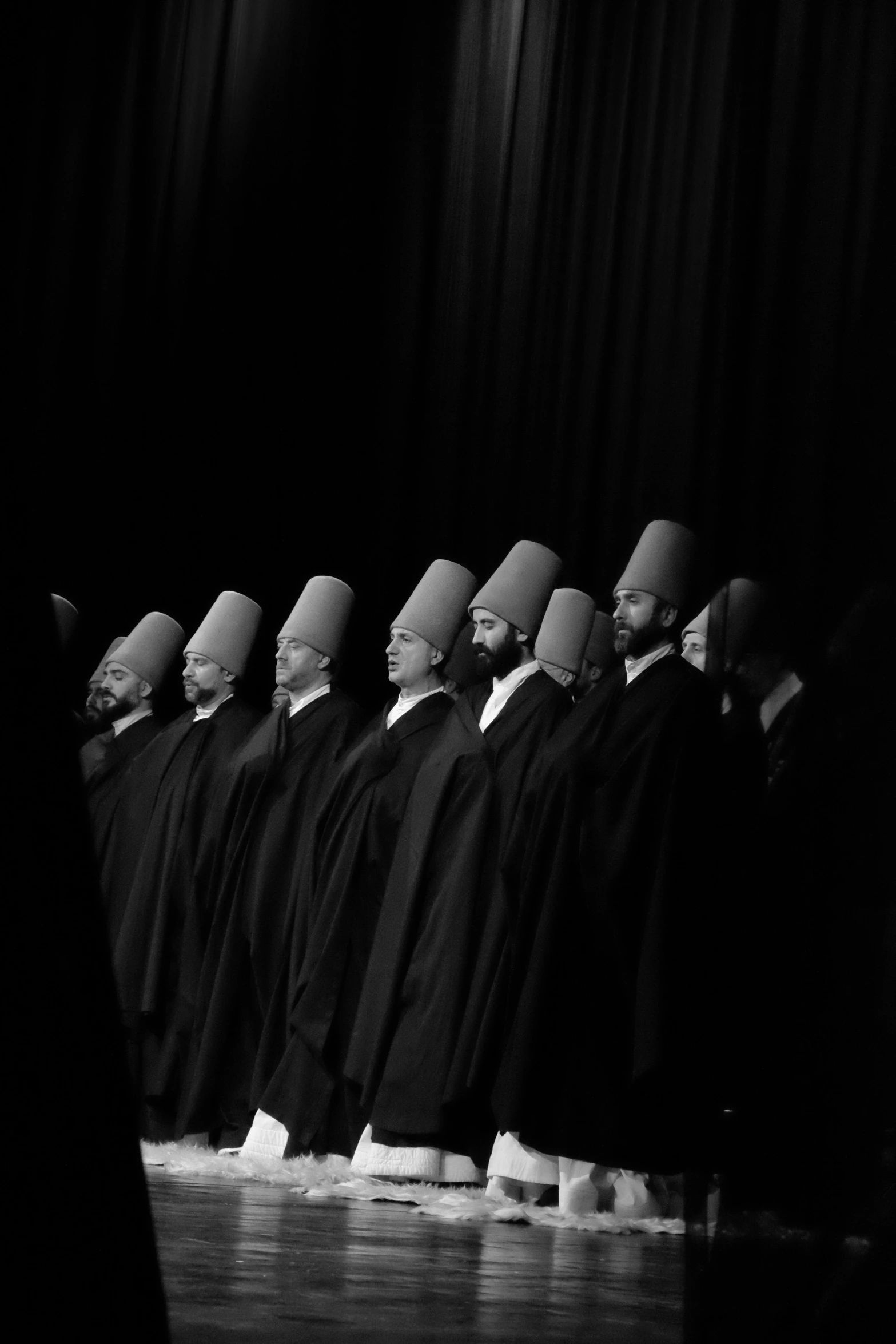 a group of men standing next to each other in front of curtains