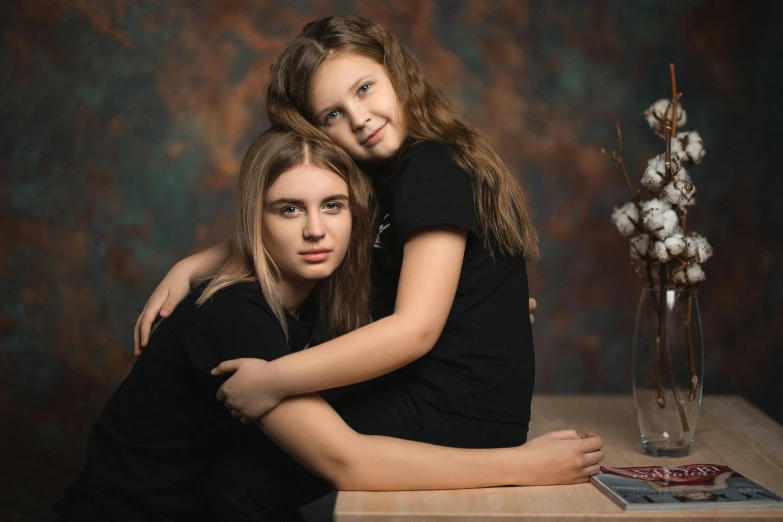 a mother is hugging her daughter while posing for a picture