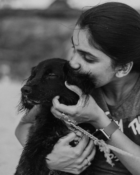 black and white image of girl kissing dog